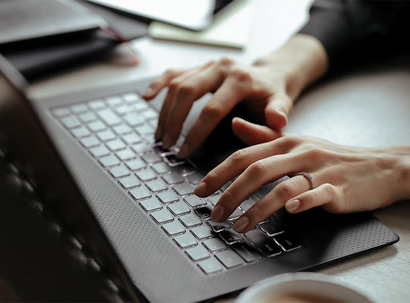 Hands typing on a computer keyboard